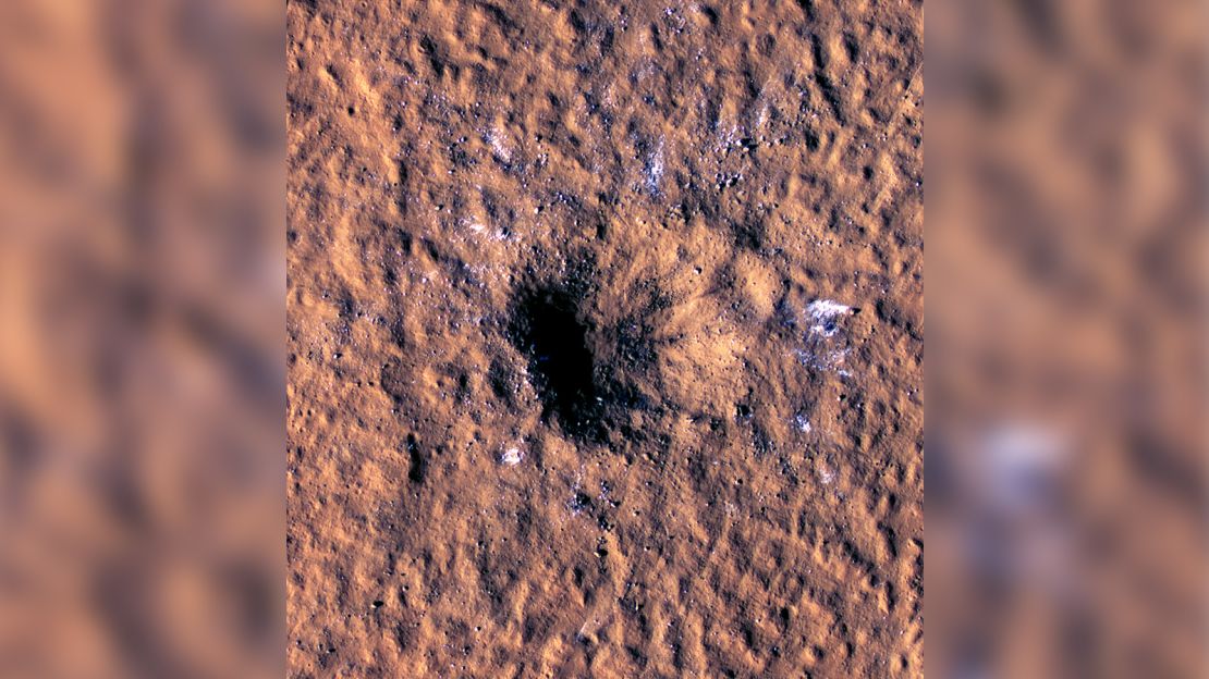Boulder-size ice chunks can be seen scattered around and outside the new crater's rim.