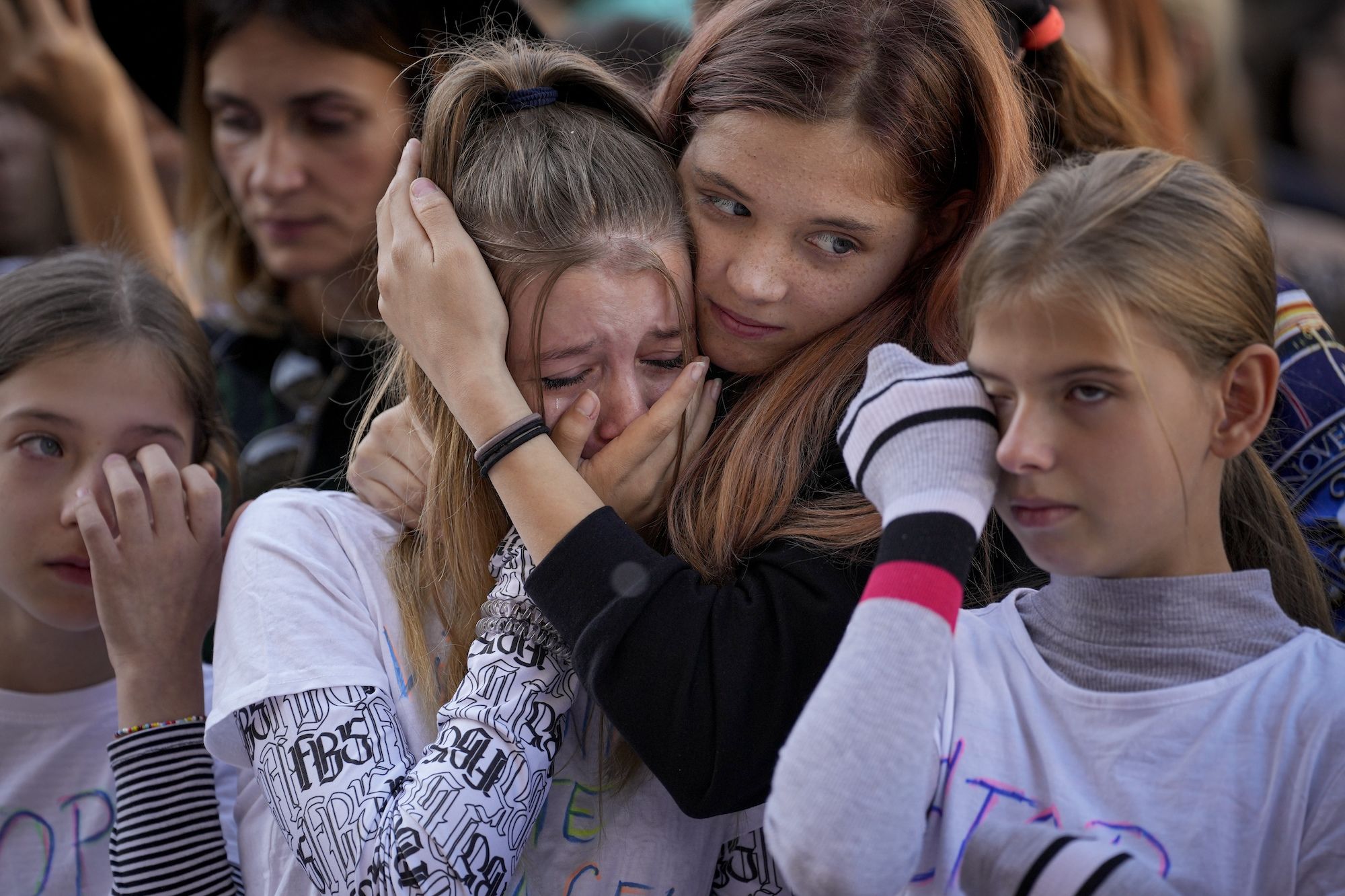 People cry while listening to a victim of domestic violence give a speech during a rally in Bucharest, Romania, on Sunday, October 23.