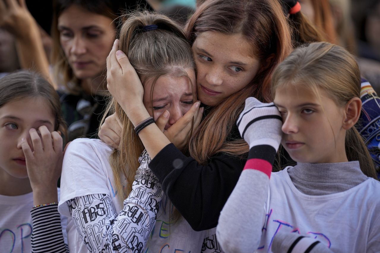 People cry while listening to a victim of domestic violence give a speech during a rally in Bucharest, Romania, on Sunday, October 23. The rally was meant to raise awareness about violence and prejudice against women in Romanian society.