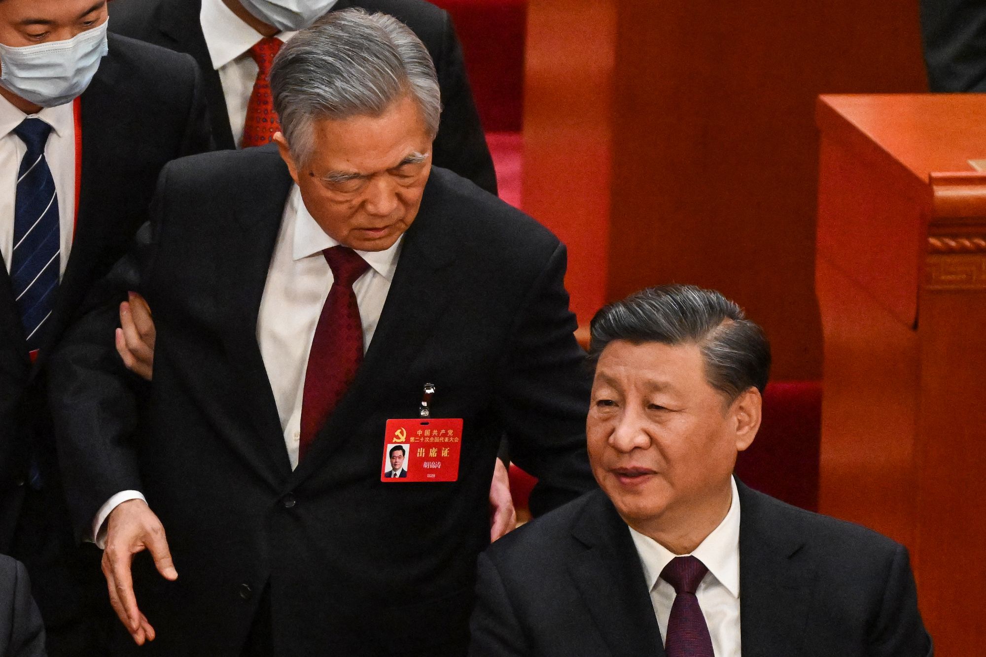 Chinese leader Xi Jinping, right, talks to former leader Hu Jintao as Hu was unexpectedly led out of the closing ceremony of the Communist Party Congress in Beijing on Saturday, October 22.