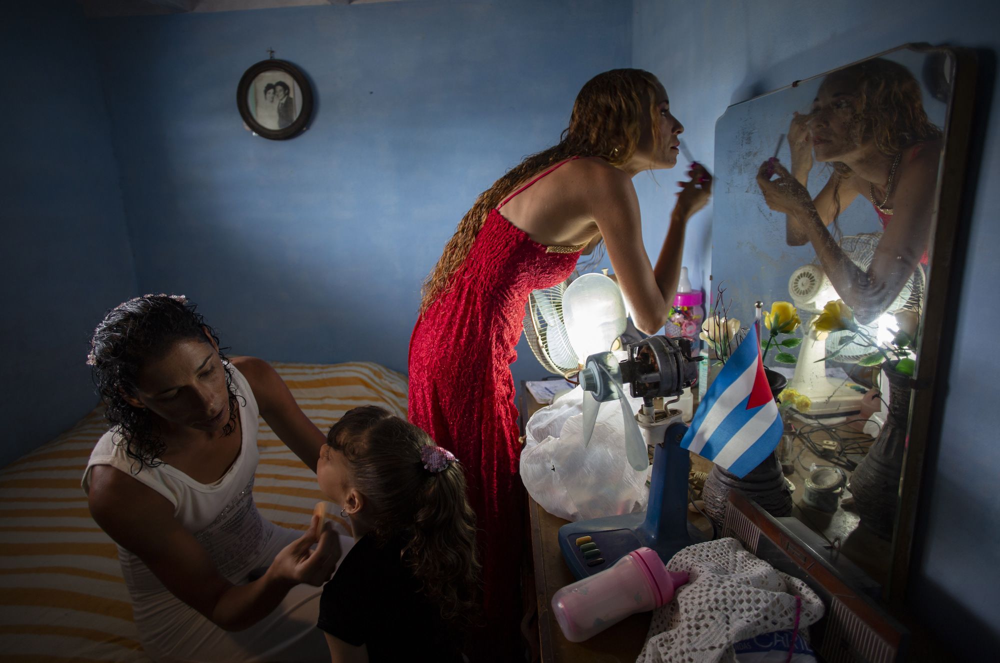 Liusba Grajales, left, puts makeup on her daughter Ainhoa as her partner, Lisset Diaz Vallejo, gets ready for their wedding in Santa Clara, Cuba, on Friday, October 21.