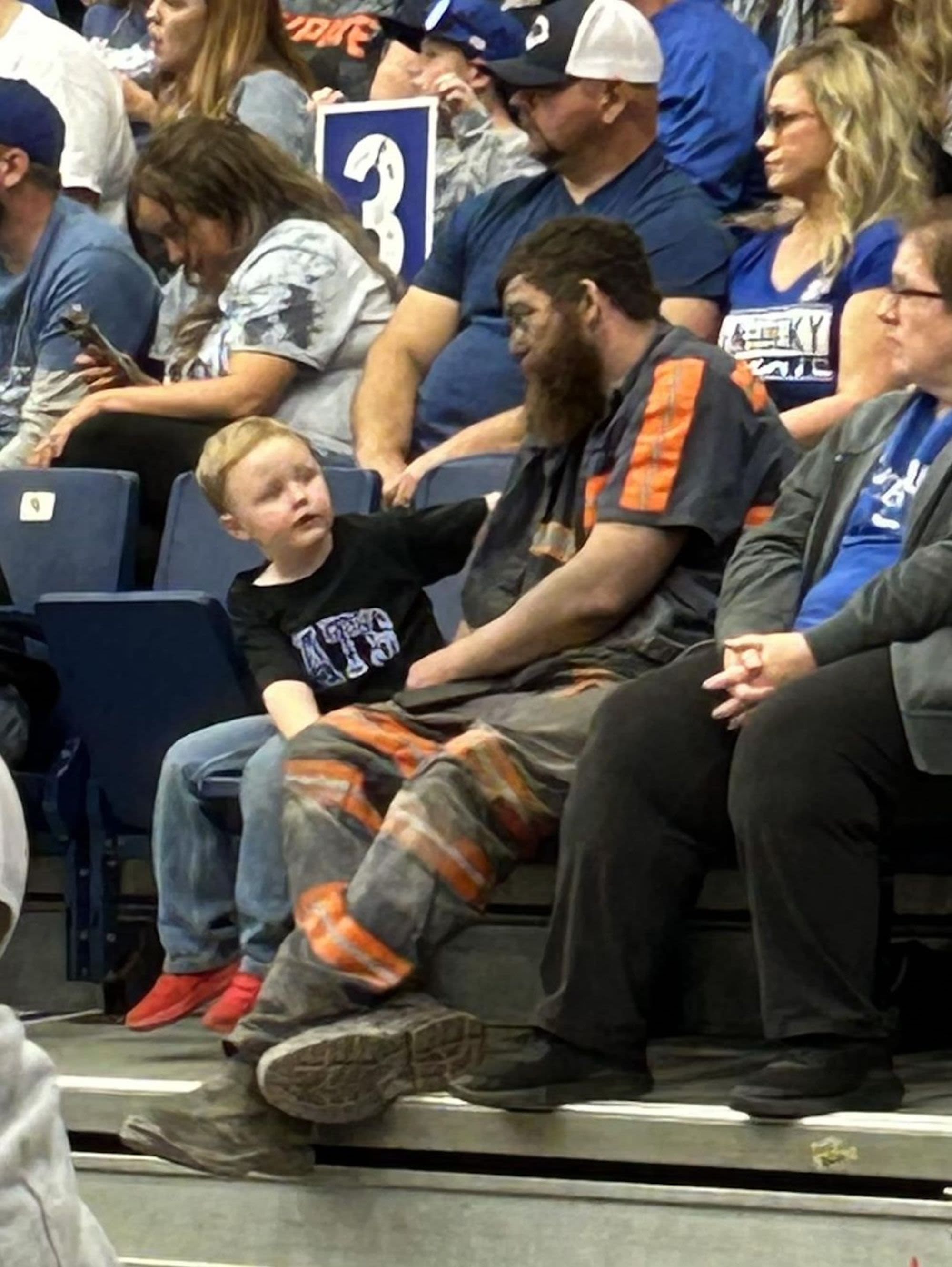 Coal miner Michael McGuire sits with his son Easton at a University of Kentucky basketball scrimmage that was played in Pikeville, Kentucky, on Saturday, October 22.