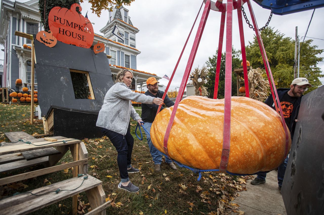 Sarah Beth Baker, left, helps other volunteers position her 1,080-pound pumpkin at the Pumpkin House in Kenova, West Virginia, on Wednesday, October 26.