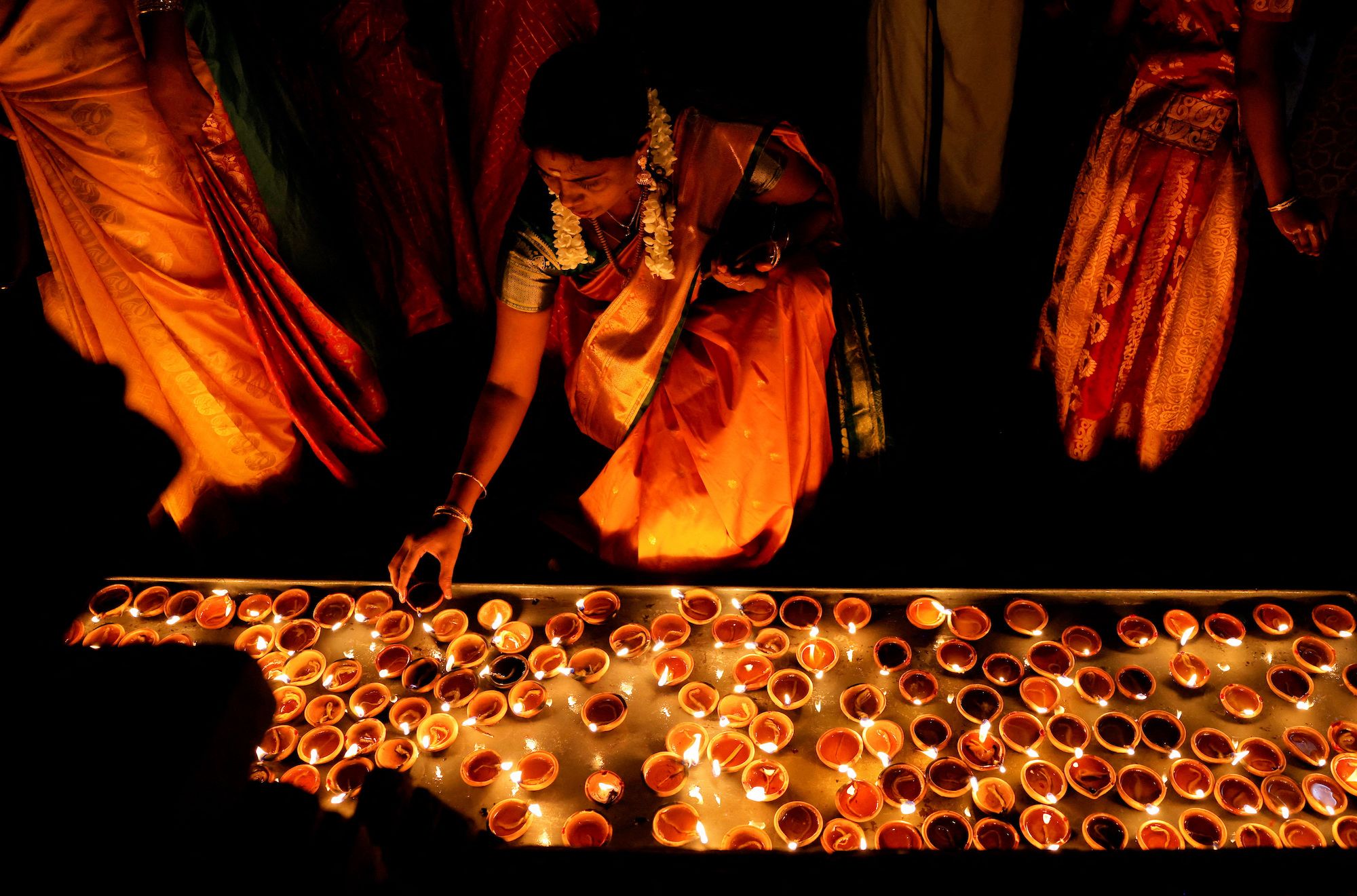 A Hindu devotee lights an oil lamp at a Diwali ceremony in Colombo, Sri Lanka, on Monday, October 24.