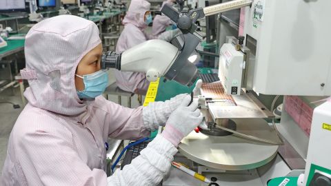 Женщина проверяет качество микросхем на заводе по производству корпусов микросхем в Наньтуне, провинция Цзянсу, Восточный Китай, пятница, 16 сентября 2022 года.