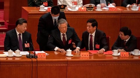 China's former leader Hu Jintao is lifted from his chair by a young aide at the closing of the Communist Party Congress on Saturday.