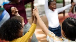 Group of diverse kindergarten students hands up together