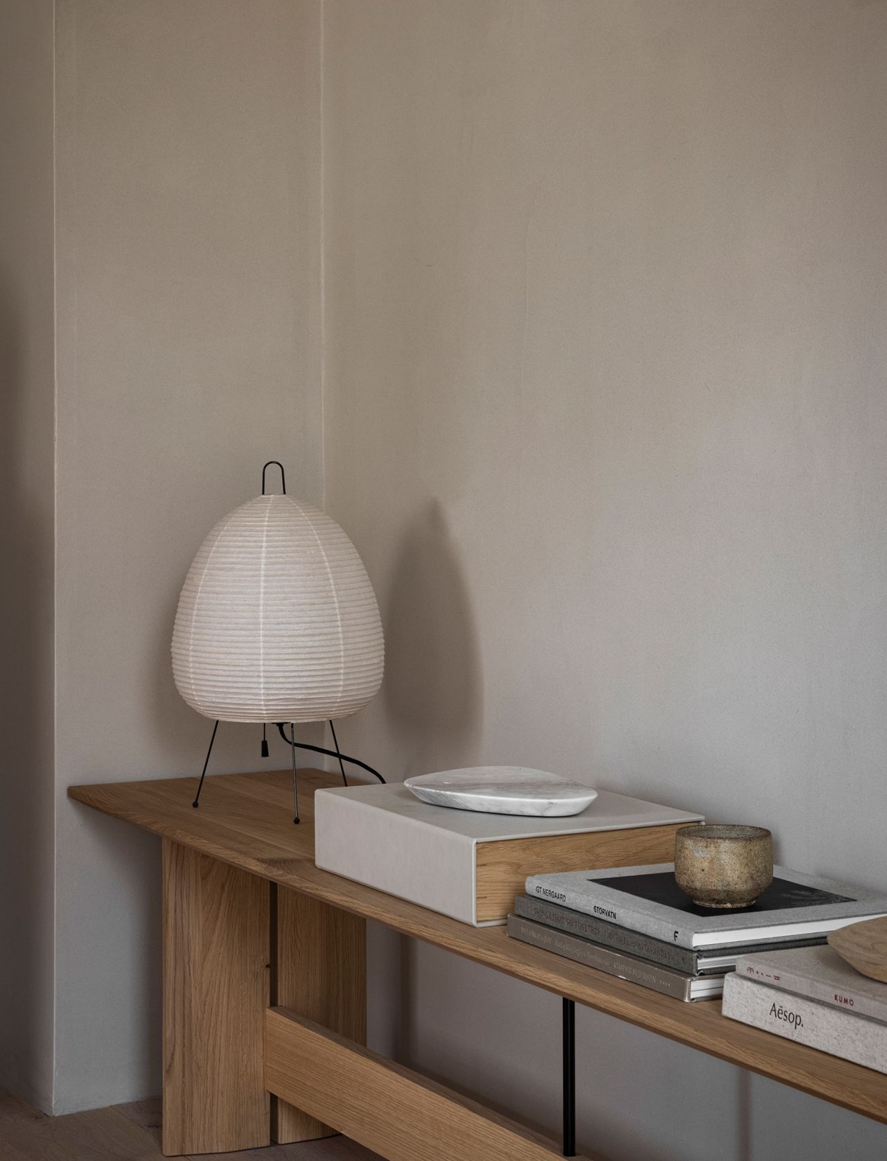 A delicate paper latern complements a neat bookshelf, designed by Norm Architects.