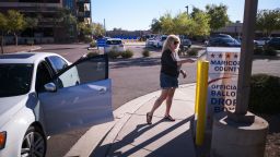 A woman drops her ballot for the upcoming midterm elections in the drop box near the Maricopa County Juvenile Court Center in Mesa, Arizona on October 25, 2022.