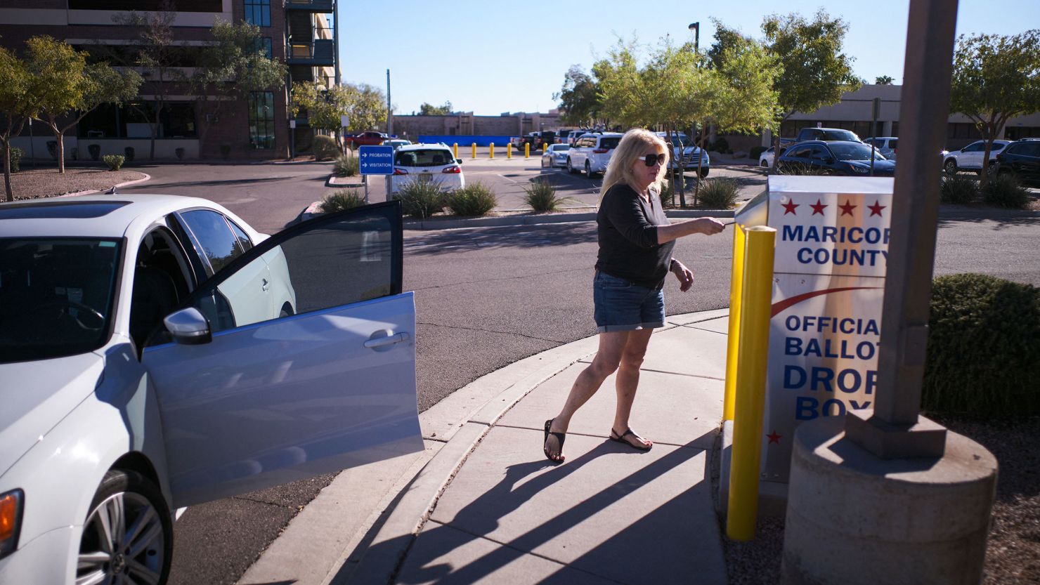 A woman drops her ballot for the upcoming midterm elections in the drop box near the Maricopa County Juvenile Court Center in Mesa, Arizona on October 25, 2022.
