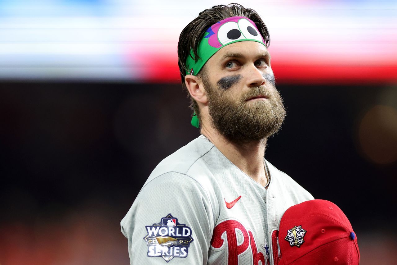 Harper, the MVP of the National League Championship Series, wears <a href="https://www.mlb.com/phillies/fans/phillie-phanatic" target="_blank" target="_blank">Phillie Phanatic</a> gear as he stands for the National Anthem on Friday.