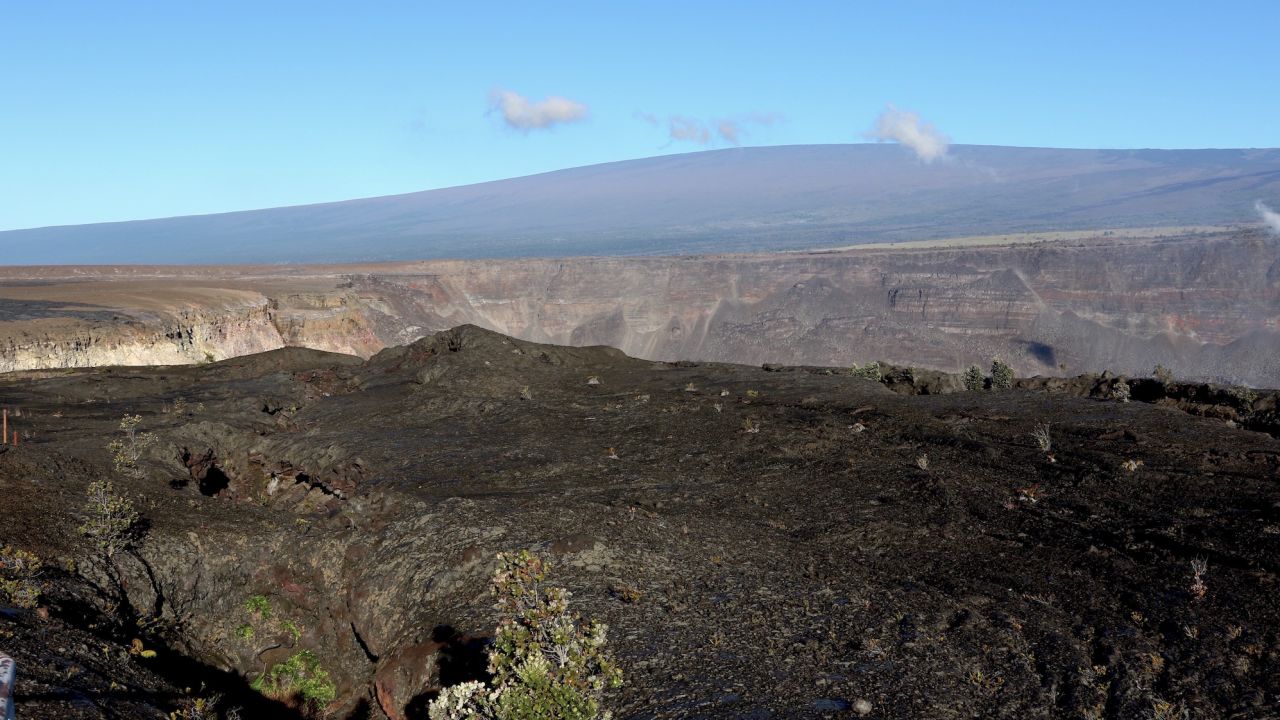 Hawaii's Mauna Loa volcano, in the background, towers over the summit crater of Kilauea volcano in Hawaii Volcanoes National Park on the Big Island on April 25, 2019.