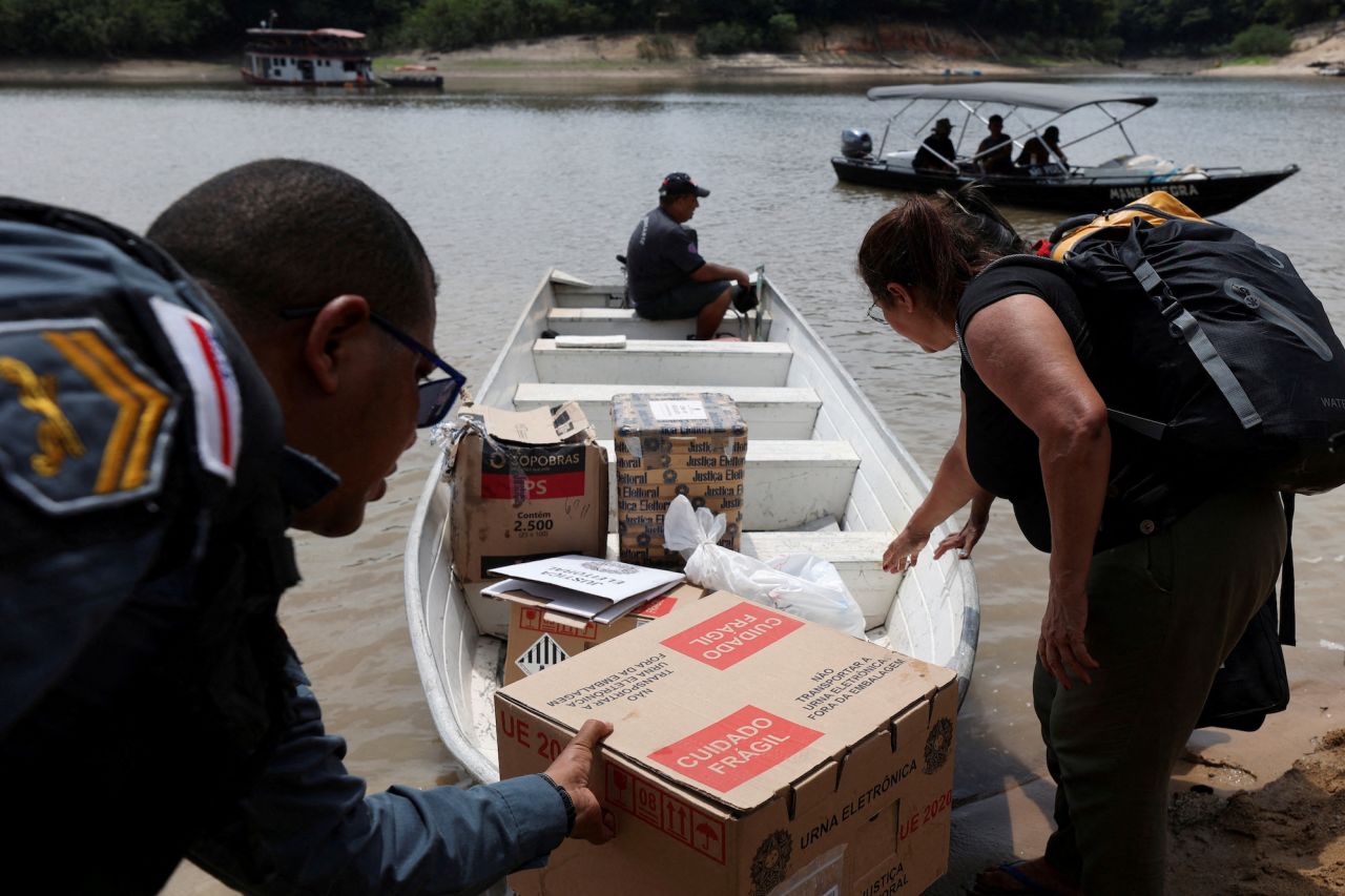 Election officials and military police officers transport electronic ballot boxes in Bela Vista do Jaraqui, Brazil, on October 29.
