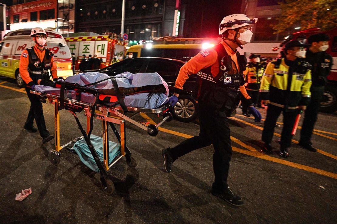 The body of a victim of a Halloween crush, which left at least 120 people dead, is transported on a stretcher in the district of Itaewon in Seoul on October 30, 2022. - At least 120 people were killed on October 29 and some 100 were injured in a stampede in central Seoul when thousands crowded into narrow streets to celebrate Halloween, officials said. (Photo by Anthony WALLACE / AFP) (Photo by ANTHONY WALLACE/AFP via Getty Images)