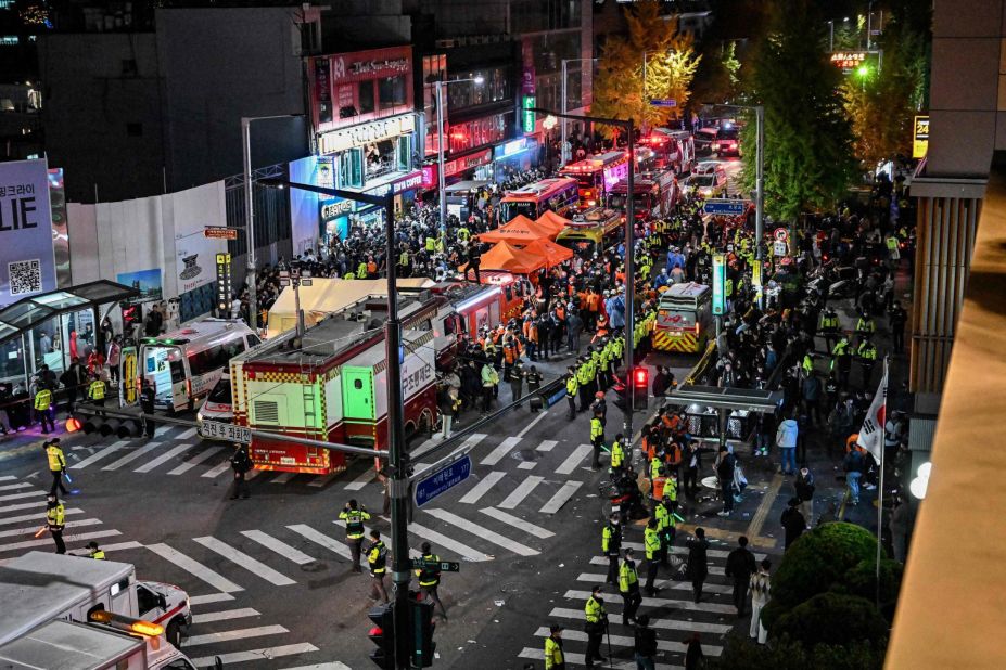 Onlookers, police and paramedics gather where dozens of people suffered cardiac arrest, in the popular nightlife district of Itaewon.