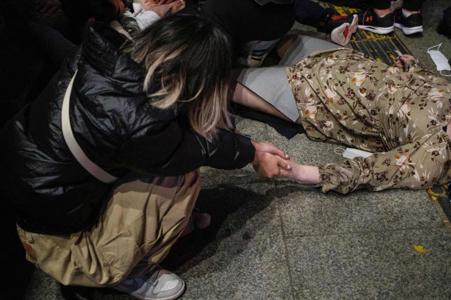 A woman holds onto the hand of a person who fell victim to the crowd surge in Seoul.