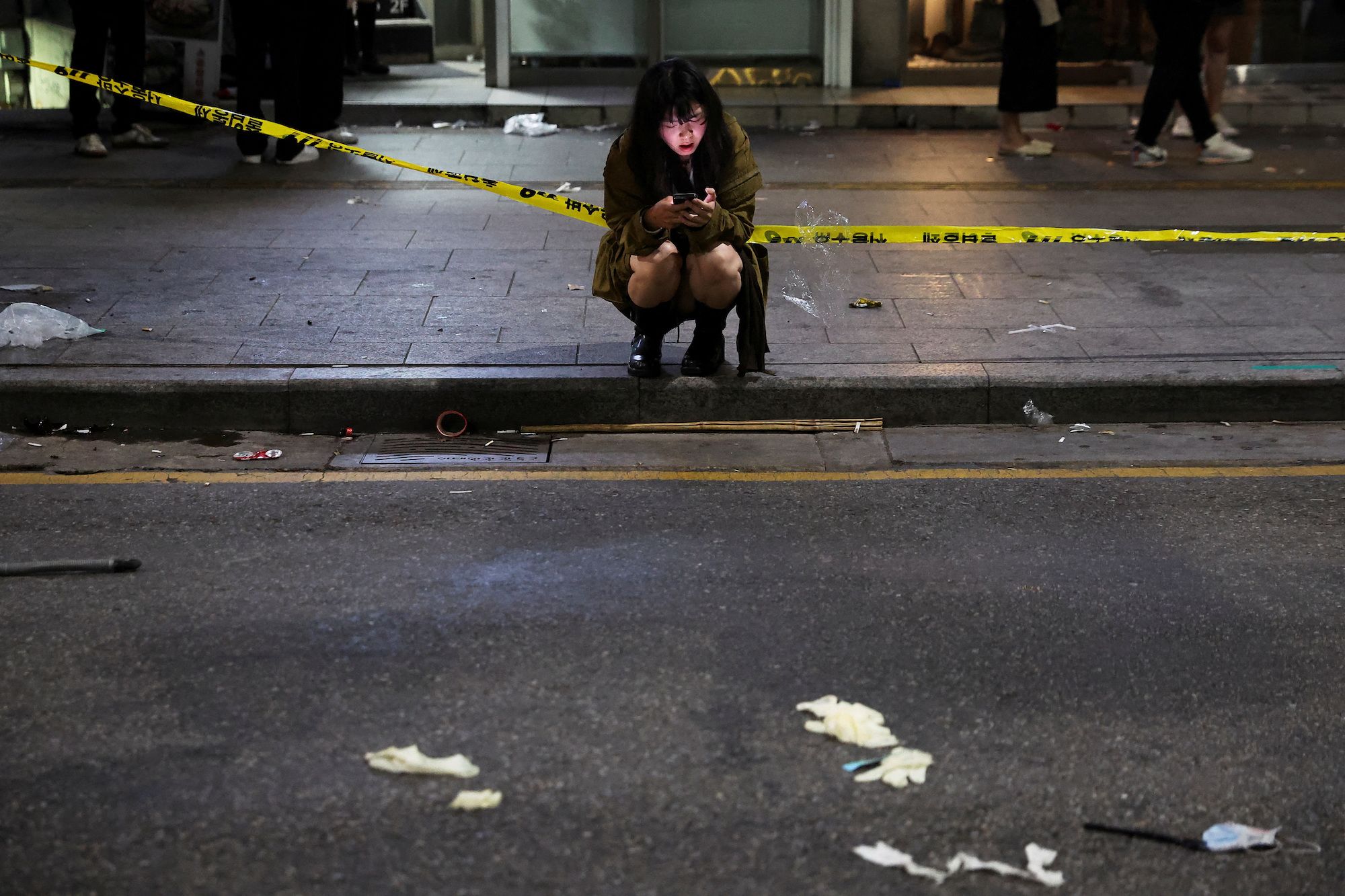 A woman uses a phone near the scene of the crash.