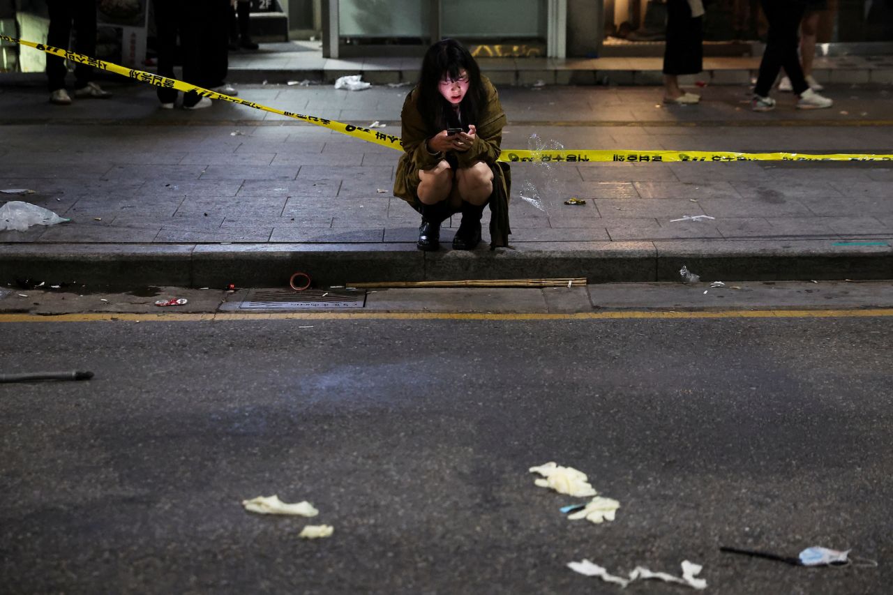 A woman uses a phone near the scene of the crush.