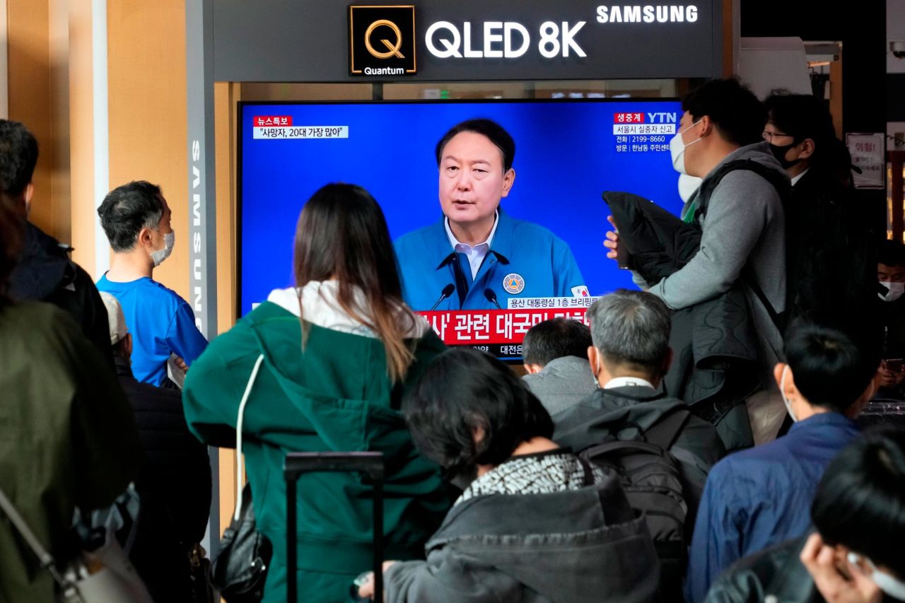 People watch a live broadcast of South Korean President Yoon Suk Yeol speaking to the nation about Saturday's deadly crowd surge.