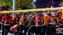 Rescue workers and firefighters work on the scene of a crushing accident in Seoul, South Korea, Saturday, Oct. 29, 2022. South Korean officials say dozens of people were in cardiac arrest after being crushed by a large crowd pushing forward on a narrow street during Halloween festivities in the capital Seoul. (Lee Ji-eun/Yonhap via AP)