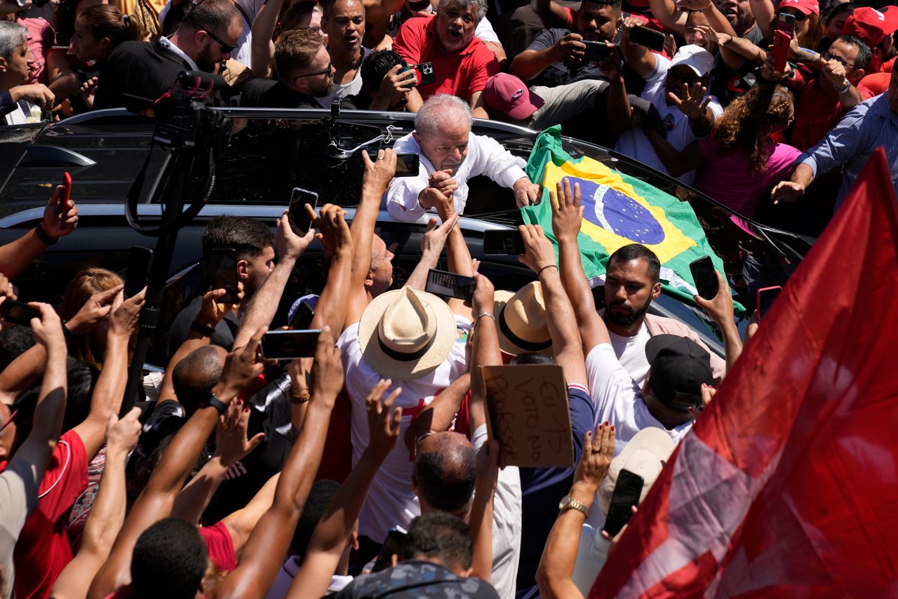 Lula holds hands with a supporter after voting in the presidential run-off election in Sao Paulo, Brazil, on Sunday, October. 30.