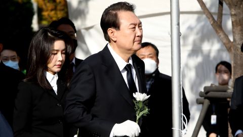 South Korean President Yoon Suk Yeol and his wife Kim Kun-hee hold flowers at a memorial altar in Seoul on October 31.