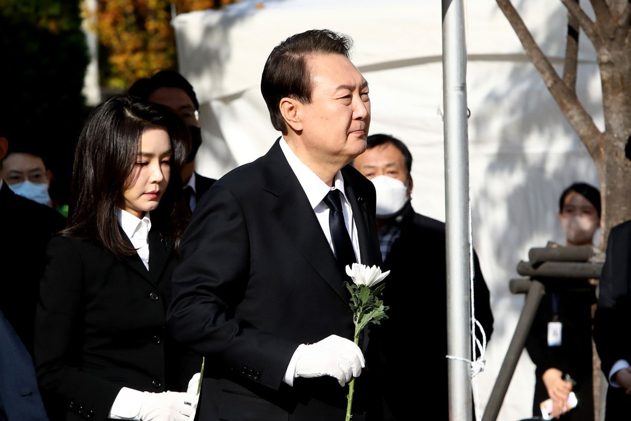 South Korean President Yoon Suk-yeol and his wife Kim Kun-hee hold flowers at a memorial altar for the victims in Seoul on October 31.