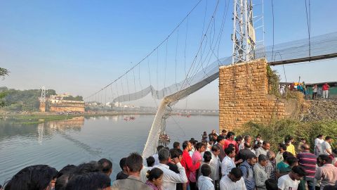 Las personas se reúnen mientras los rescatistas buscan a los rescatistas después de que un puente colgante se derrumbara en Morbi, el estado de Gujarat, en el oeste de la India, el 31 de octubre de 2022. 