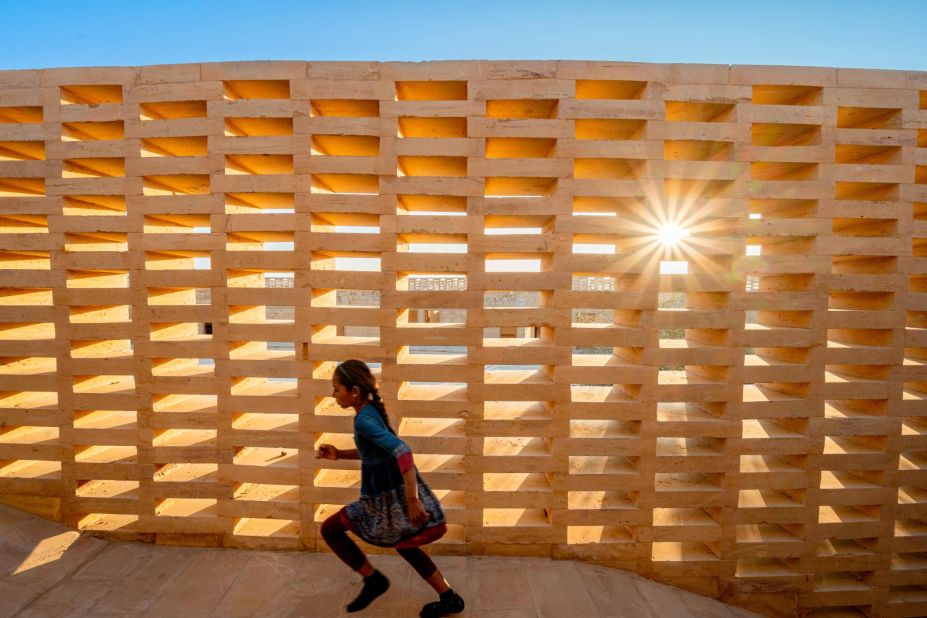 Wrapping around the school are gridded jalis walls. These sandstone lattices provide shade from the sun while also accelerating wind flow which helps to cool down the school grounds. 