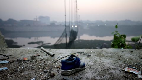 Ein Schuh steht am 1. November 2022 neben einer beschädigten Hängebrücke in Morbi, Indien. 