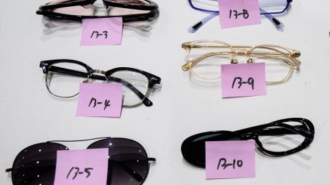 Sunglasses and spectacles are laid out in rows for collection by mourning families.