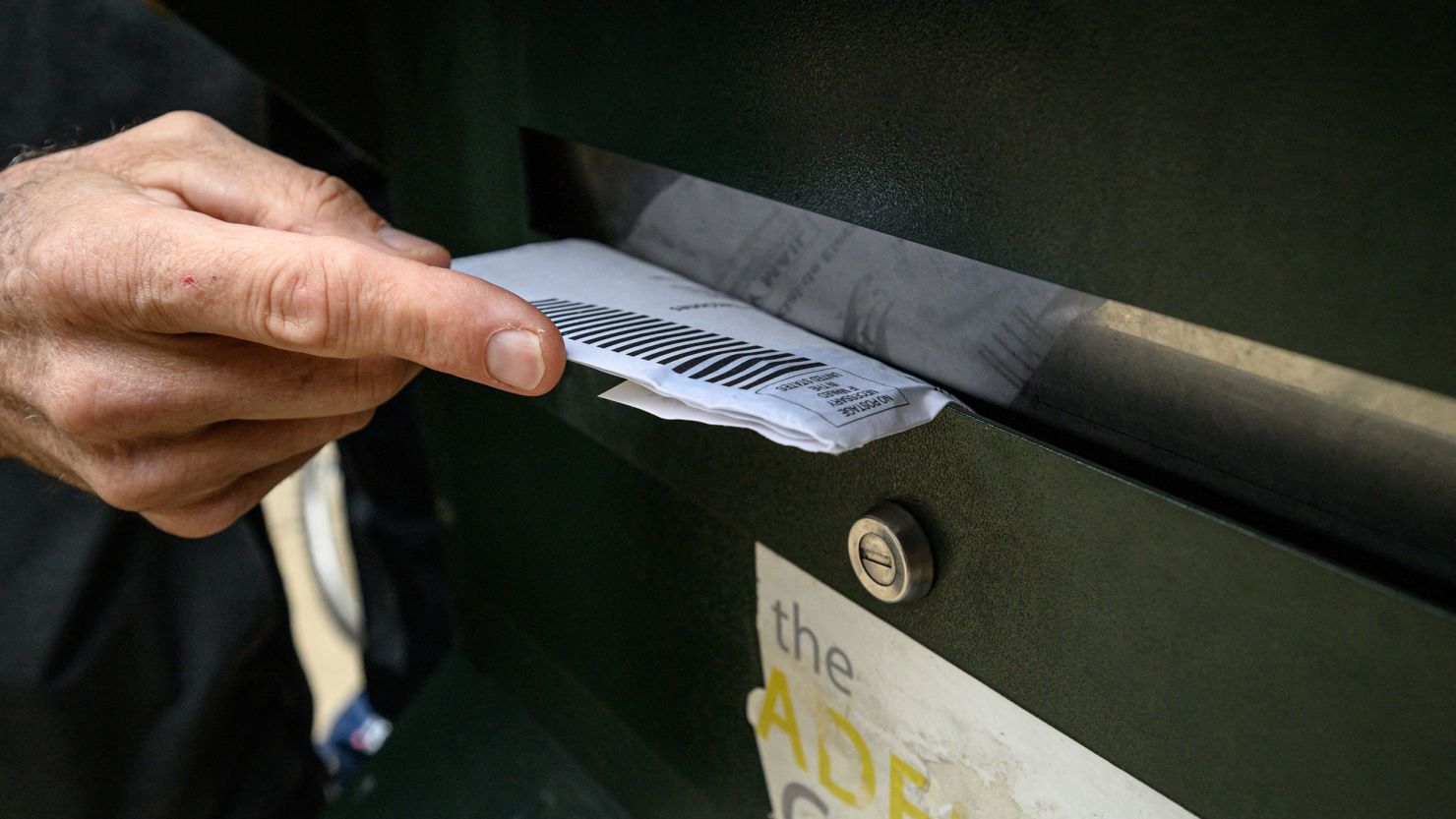 A voter casts their ballot at a drop box is displayed outside Philadelphia city hall on October 24, 2022. 