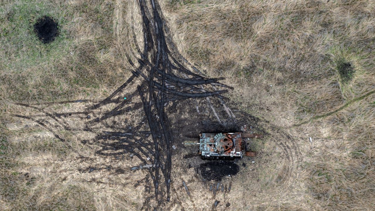 Artillery and mortar craters pierce the ground next to a destroyed Russian tank, on October 23, 2022 in Kam'yanka, Kharkiv oblast, Ukraine.