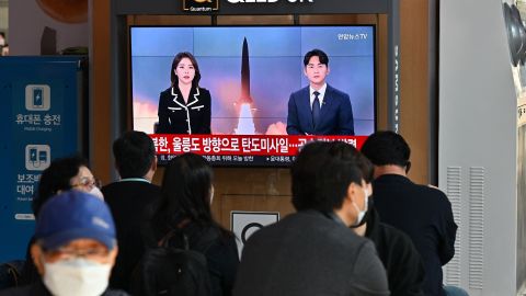 People watch a TV screen showing a newscast showing file footage of a North Korean missile test at a train station in Seoul on November 2, 2022.