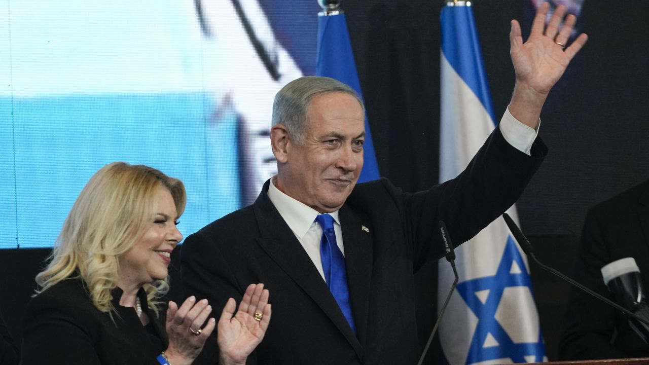 Benjamin Netanyahu, former Israeli Prime Minister and the head of Likud party, accompanied by his wife Sara waves to his supporters after first exit poll results for the Israeli Parliamentary election at his party's headquarters in Jerusalem, Wednesday, Nov. 2, 2022. (AP Photo/Tsafrir Abayov)