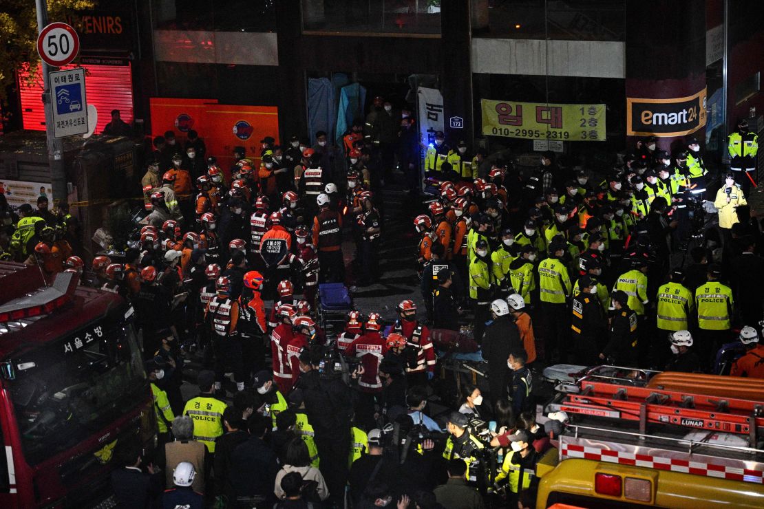 Rescue officials and police gather in the district of Itaewon in Seoul on October 30, 2022, after a Halloween crush which left at least 120 people dead. - At least 120 people were killed on October 29 and some 100 were injured in a stampede in central Seoul when thousands crowded into narrow streets to celebrate Halloween, officials said. (Photo by Anthony WALLACE / AFP) (Photo by ANTHONY WALLACE/AFP via Getty Images)