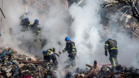 Украинские спасатели работают в жилом доме, разрушенном в результате удара российского беспилотника, который местные власти считают иранским, в Киеве 17 октября. 