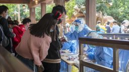 SHANGHAI, CHINA - OCTOBER 31: Medical workers carry out COVID-19 nucleic acid testing on tourists at Shanghai Disney Resort on October 31, 2022 in Shanghai, China. Shanghai Disney Resort announced its temporary closure on Monday after a recent visitor tested positive for COVID-19. (Photo by VCG/VCG via Getty Images)