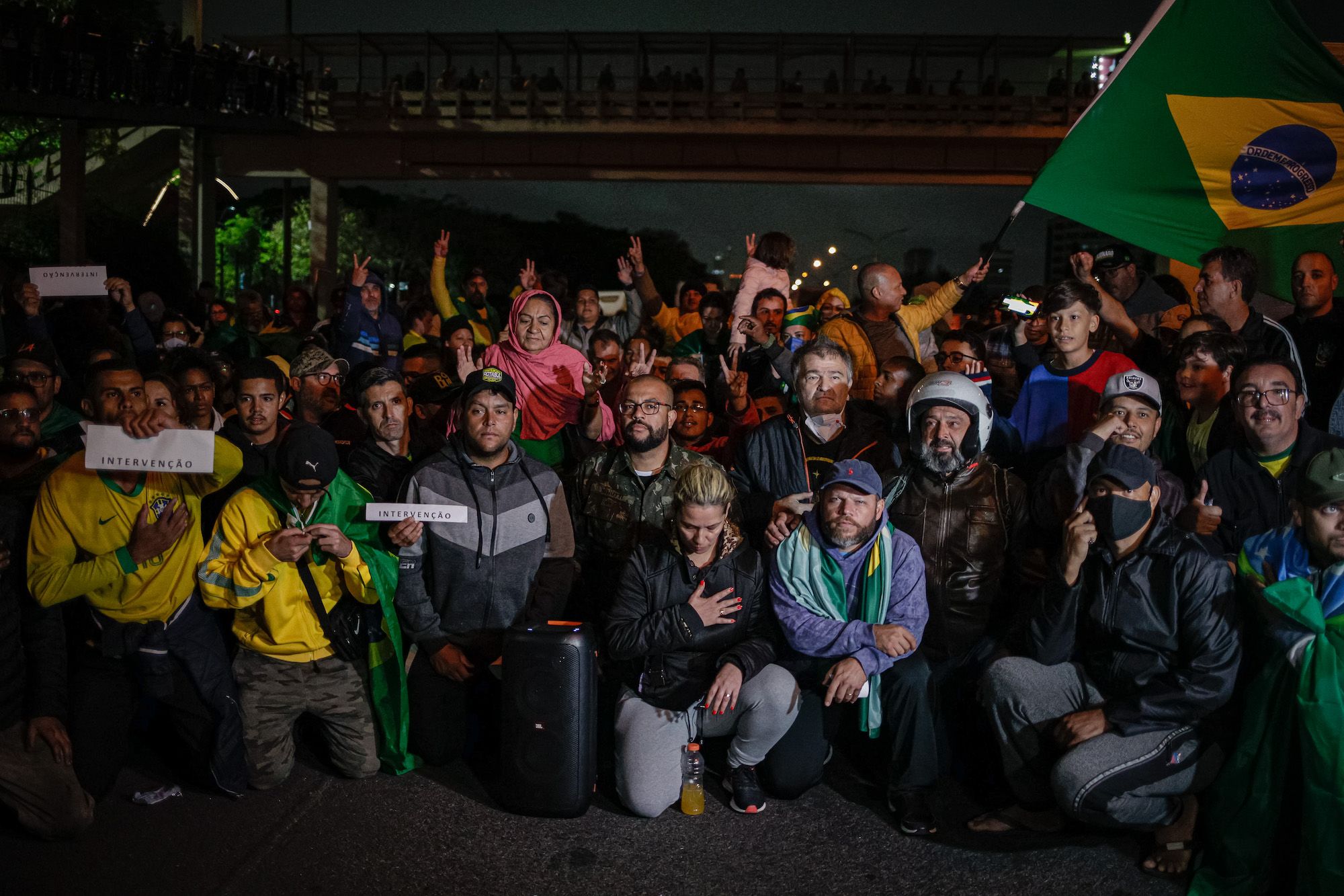 Demonstrators kneel during a protest on a highway in São Paulo on Tuesday, November 1.