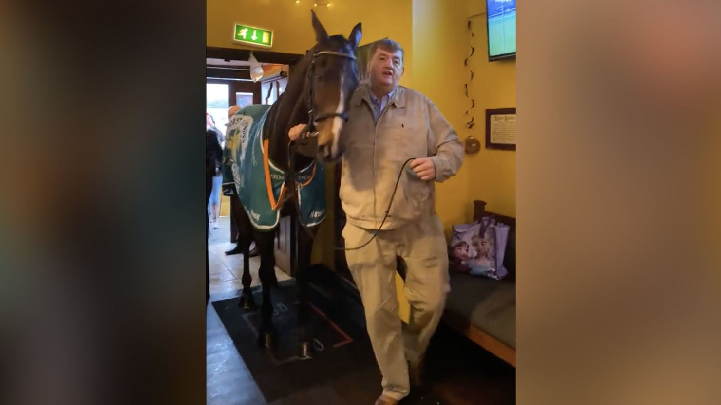 Racehorse Hewick being led into a pub by its trainer. 