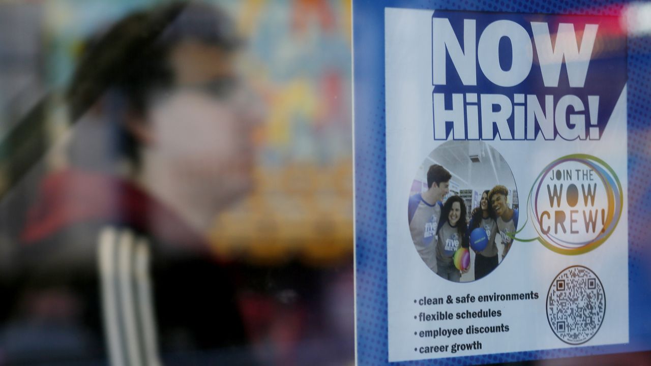 A "Now Hiring" sign is displayed on a shopfront on October 21 in New York City.