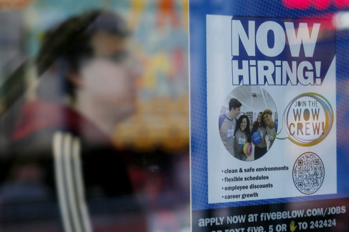 A "Now Hiring" sign is displayed on a shopfront on October 21 in New York City.