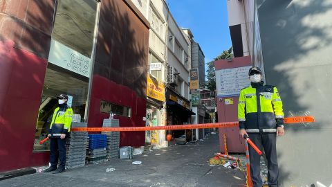 Police stand guard next to the alley where a fatal crowd crush took place during Halloween celebrations in the district of Itaewon in Seoul.