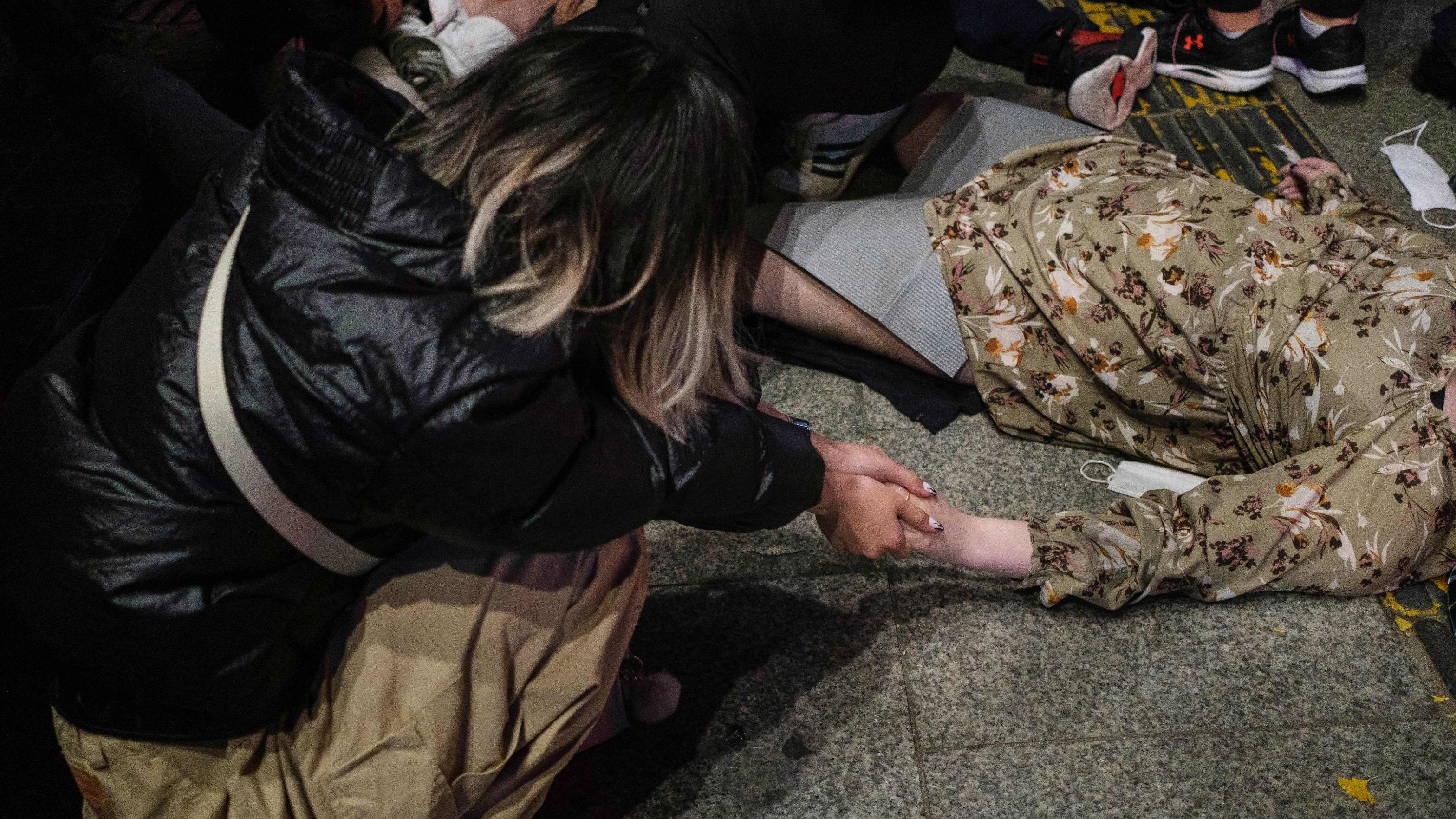 A woman holds the hand of a person who was caught in <a href="https://www.cnn.com/2022/10/30/world/gallery/seoul-crowd-surge-gallery" target="_blank">a crowd surge</a> in Seoul early Sunday, October 30.
