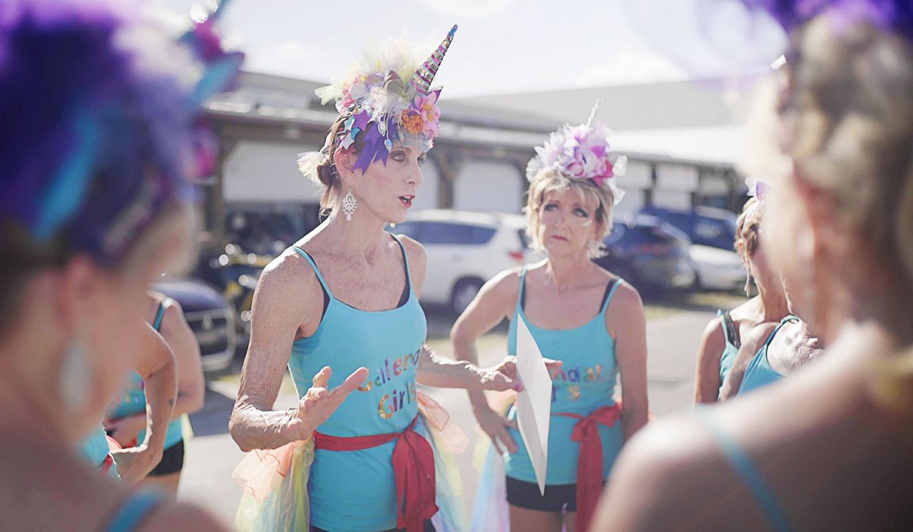 Calendar Girls ready to dance in unicorn hats and rainbow tutus.
