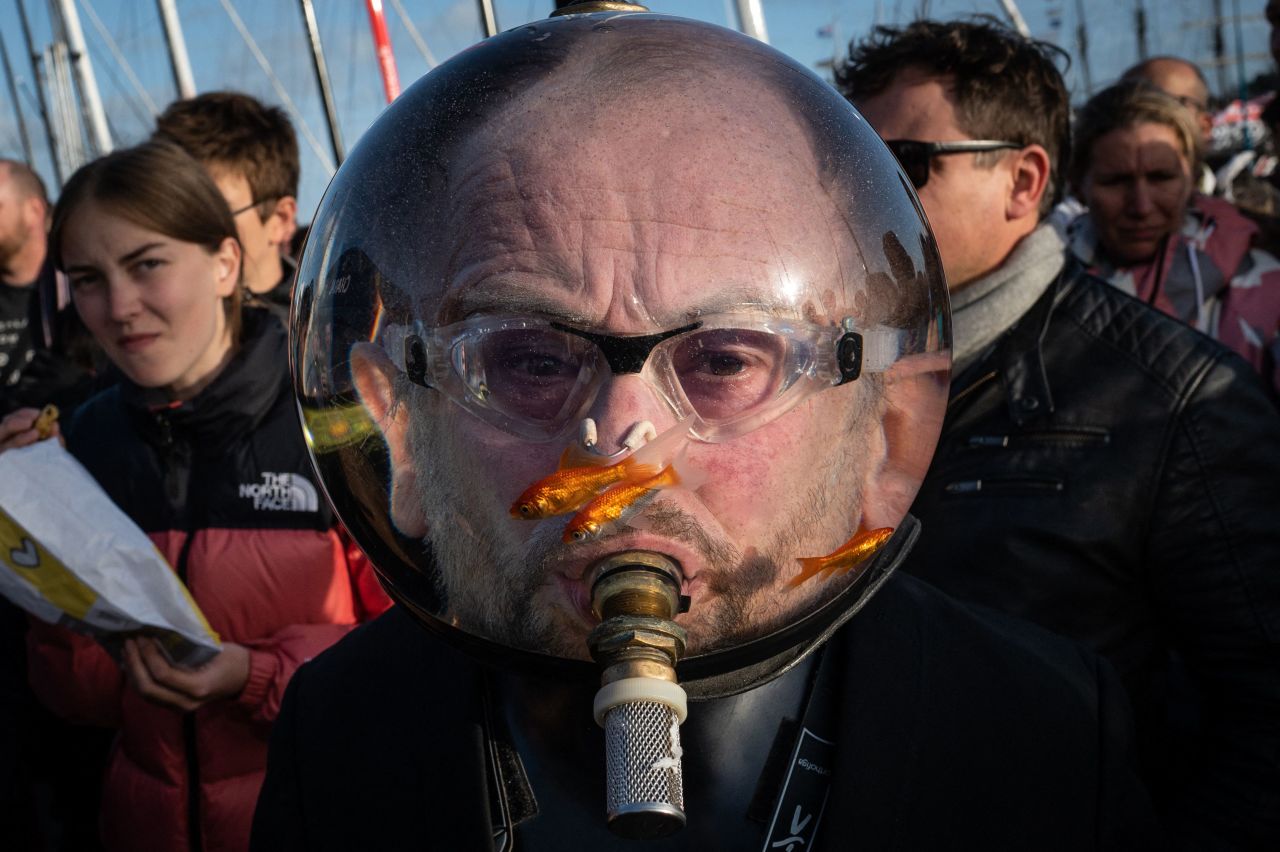 A man wearing an aquarium with goldfish on his head is seen at the starting point of the Route du Rhum sailing race in Saint-Malo, France, on Tuesday, November 1. 