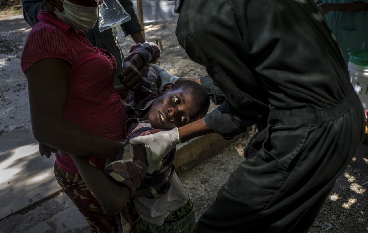 A child suffering cholera symptoms is helped upon arrival at a clinic in Port-au-Prince, Haiti, on Thursday, October 27.