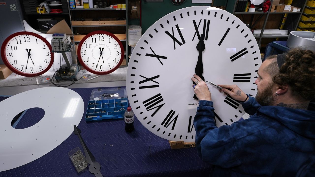 Ian Roders fastens the hands to a clock at the Electric Time Company in Medfield, Massachusetts, on Tuesday, November 1. Daylight saving time ends at 2 a.m. on Sunday, November 6, when clocks in the US are set back one hour.