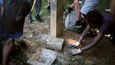 Volunteers excavate the headstone of Pfc. Floyd Suber, a World War I veteran.