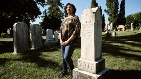 Samantha Dorm poses by a headstone for the Fells family, one of many forks in Dorm's sprawling family tree.